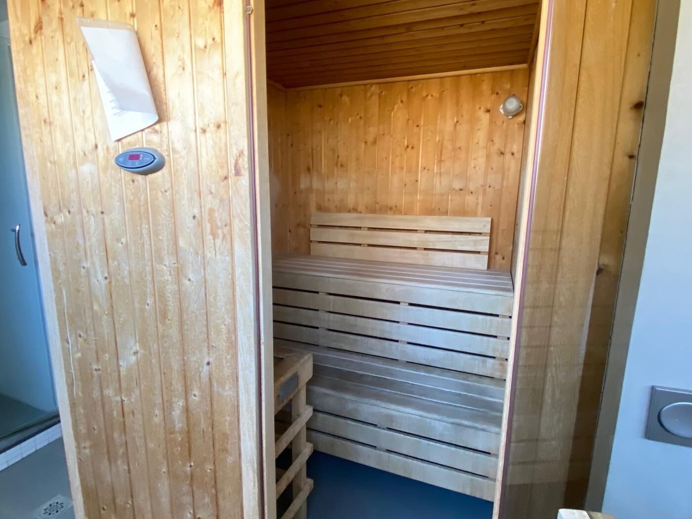A wooden sauna with benches and a bench seat.