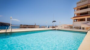 A clear blue pool with a view of the sea, a building labeled 'Cactus', and a lifeguard tower. - Heart of Los Cristianos,Heated Pool (Los Cristianos)