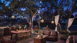 An outdoor patio area with tables, chairs, and a sofa set.