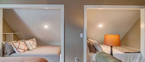 Una habitación con dos camas, un sofá y una lámpara.