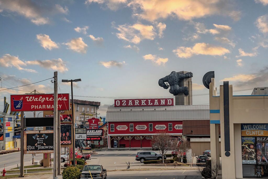 A building with a large sign reading "Ozarkland" and a prominent bull sculpture.