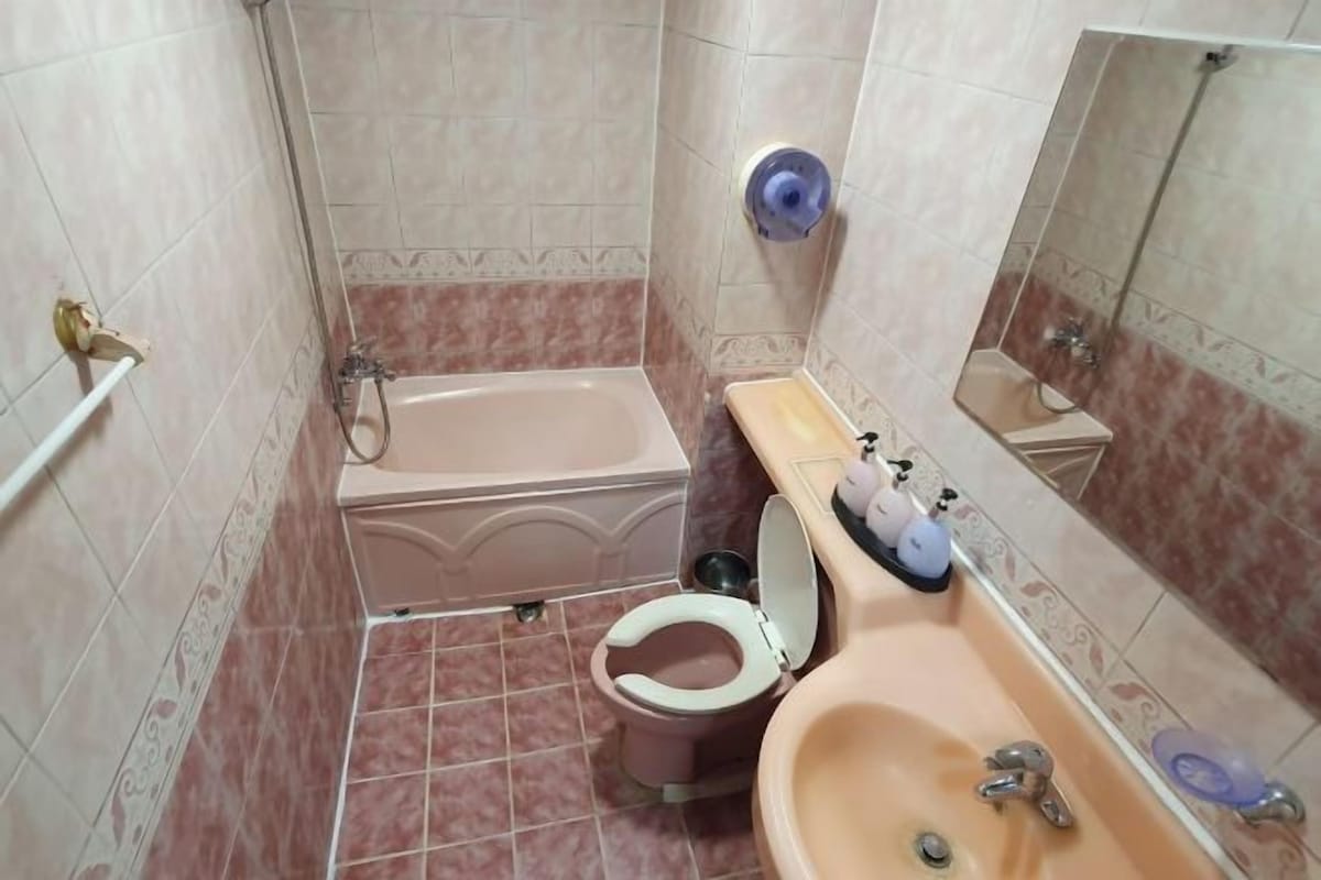 Un baño con bañera, inodoro, lavabo y espejo.