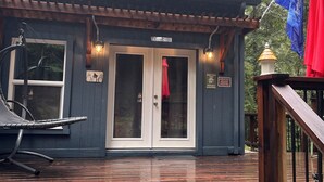 Uma cabana com um deck de madeira, um alpendre coberto e uma placa indicando ser uma área de vida selvagem particular.
