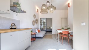 Una cucina moderna con un piano di lavoro in legno, un bollitore e un'area pranzo con tavolo e sedie.
