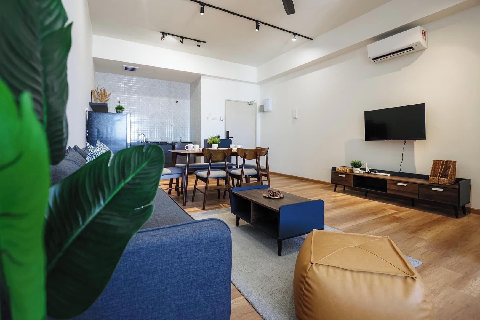 A modern living room with a sofa, coffee table, and TV stand.