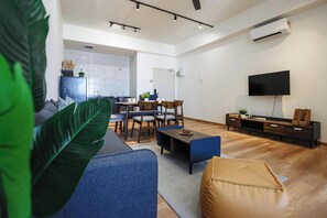 A modern living room with a sofa, coffee table, and TV stand.