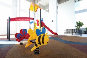 Zona de juegos infantiles con tobogán y estructuras para escalar.