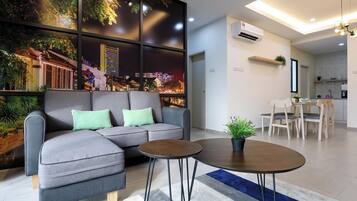 A modern living room with a sectional sofa, a round coffee table, and a dining area with a table and chairs.