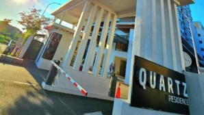 Een hoog gebouw met een bord waarop 'QUARTZ RESIDENCE' staat.