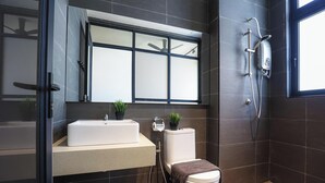 Een moderne badkamer met een witte wastafel, toilet en douche.