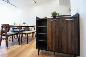 Un intérieur moderne avec un meuble en bois, une table à manger avec des chaises et une plante en pot.