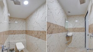 A bathroom with a toilet, shower, and sink. - Hotel Planet Villa (Ahmedabad)