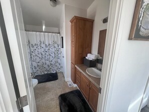 A bathroom with a shower, toilet, and sink.