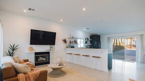 Una sala moderna con un sofá, una mesa de centro y un televisor de pantalla plana.