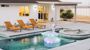 Una piscina con sillones de descanso y flotadores con forma de cisne.