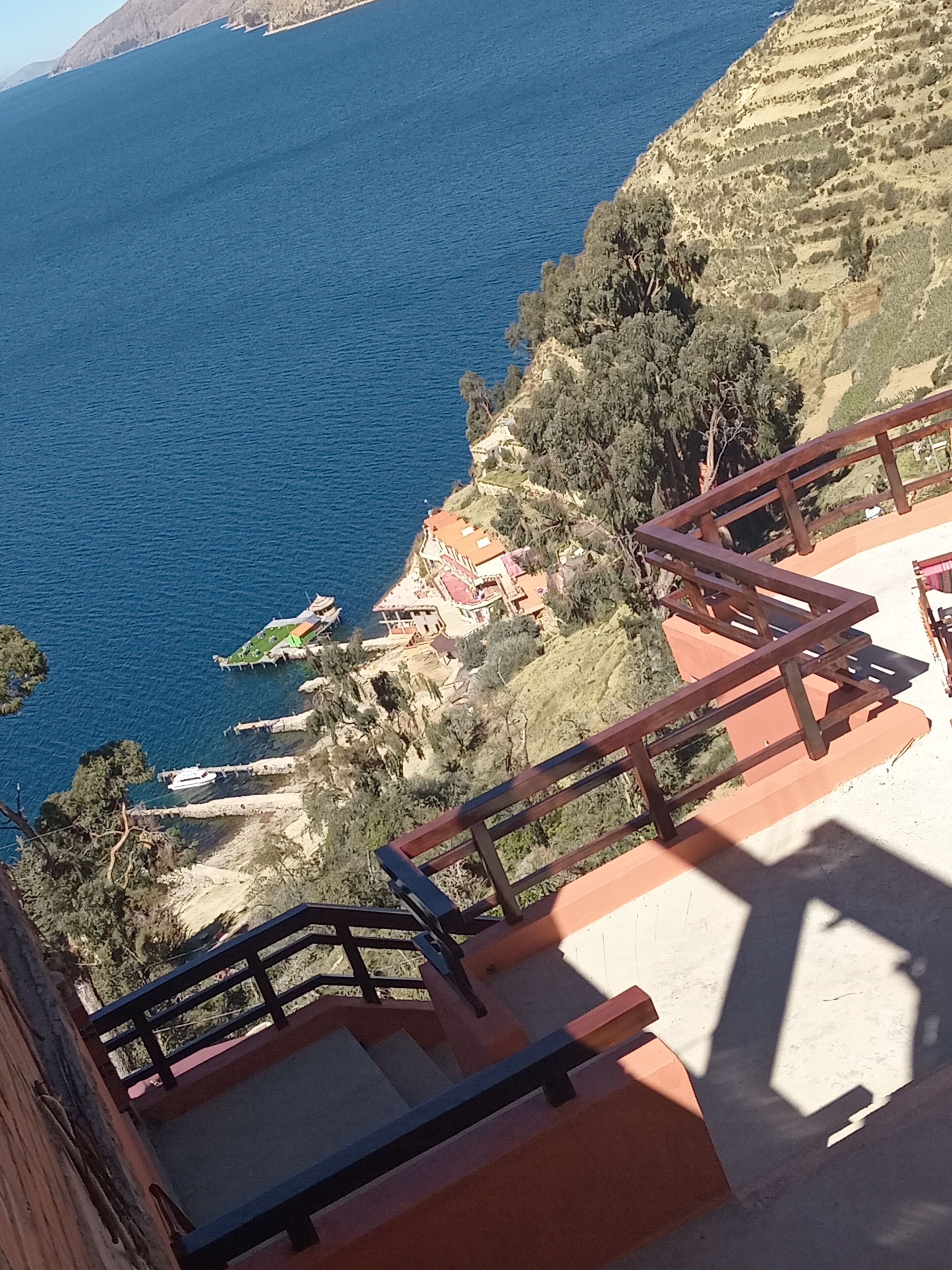 A coastal view with a staircase leading to a terrace overlooking the sea.