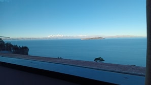 A view of a calm sea with distant mountains and a clear sky. - Sol y Luna Lodge Isla del Sol Bolivia (Isla del Sol)