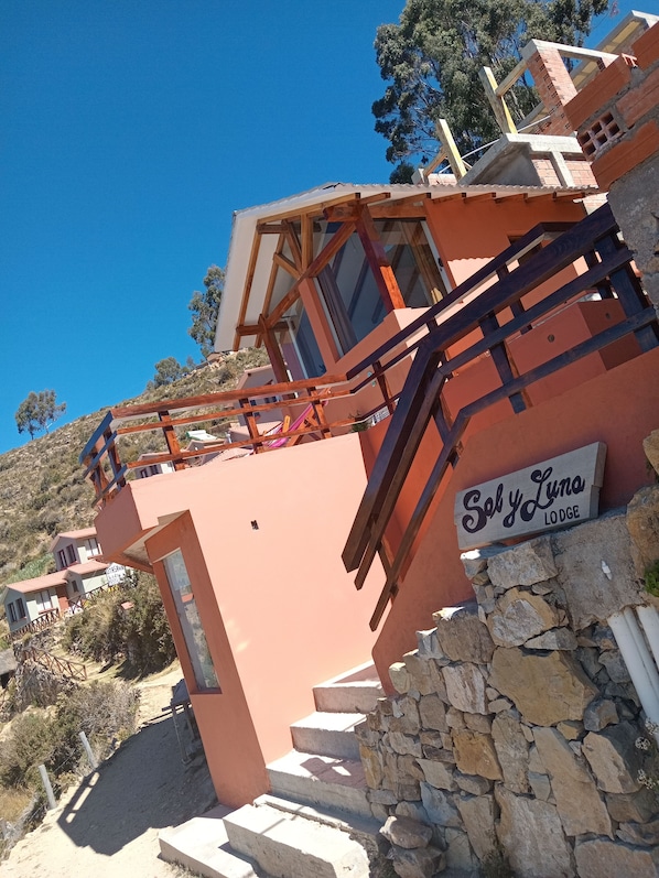 Una cabaña llamada "Sely Luna" con una escalera de piedra que lleva a una terraza de madera.