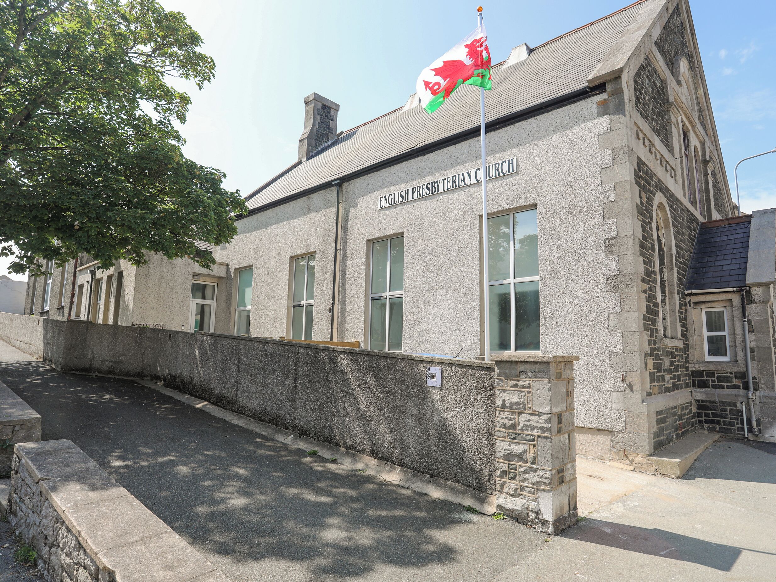 Ein Gebäude mit der Aufschrift „ENGLISHT PRESBYTERIAN CHURCH“, einer Fahnenstange und einer Flagge.