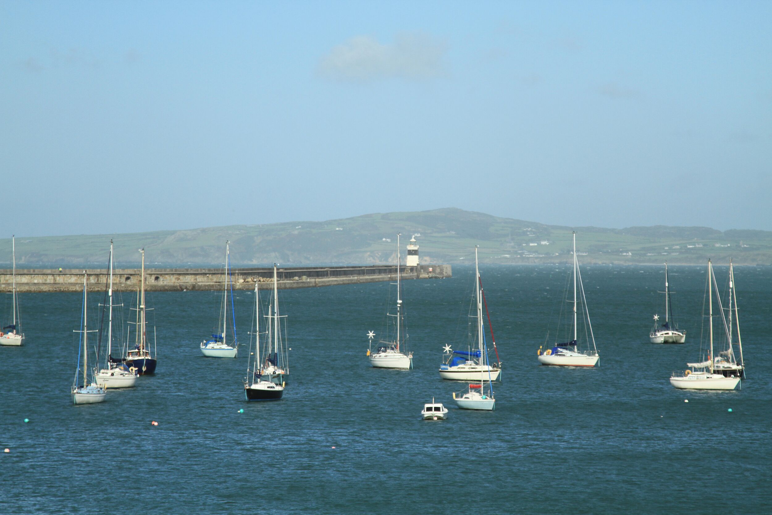 A harbor with multiple sailboats docked at a pier.