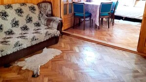 Un interior de madera con un sofá, una mesa de comedor con sillas y una puerta que da al exterior.