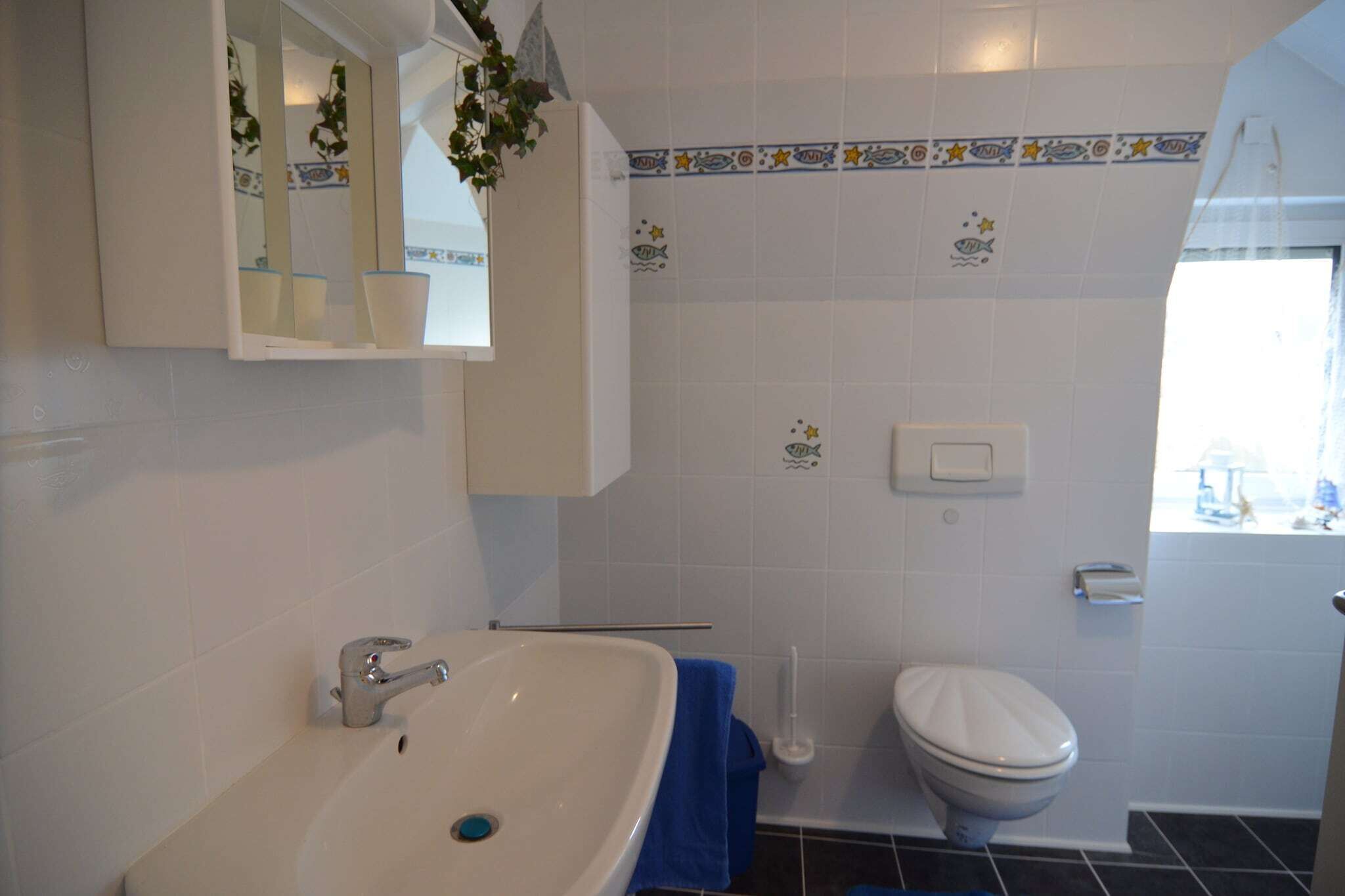 A bathroom with a white sink, a toilet, and a mirror above the sink.