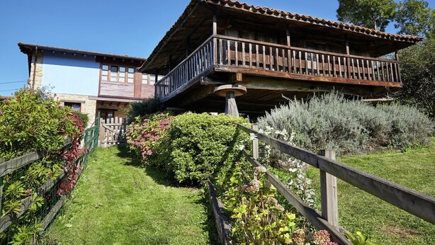 A rustic wooden house with a balcony, surrounded by a well-maintained garden. - Cozy Cottage with Pool & Terrace (Nava)