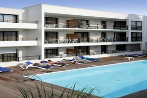 A modern hotel with a rooftop pool area, multiple balconies, and lounge chairs. - Apartment in La Rochelle near the Beach (La Rochelle)