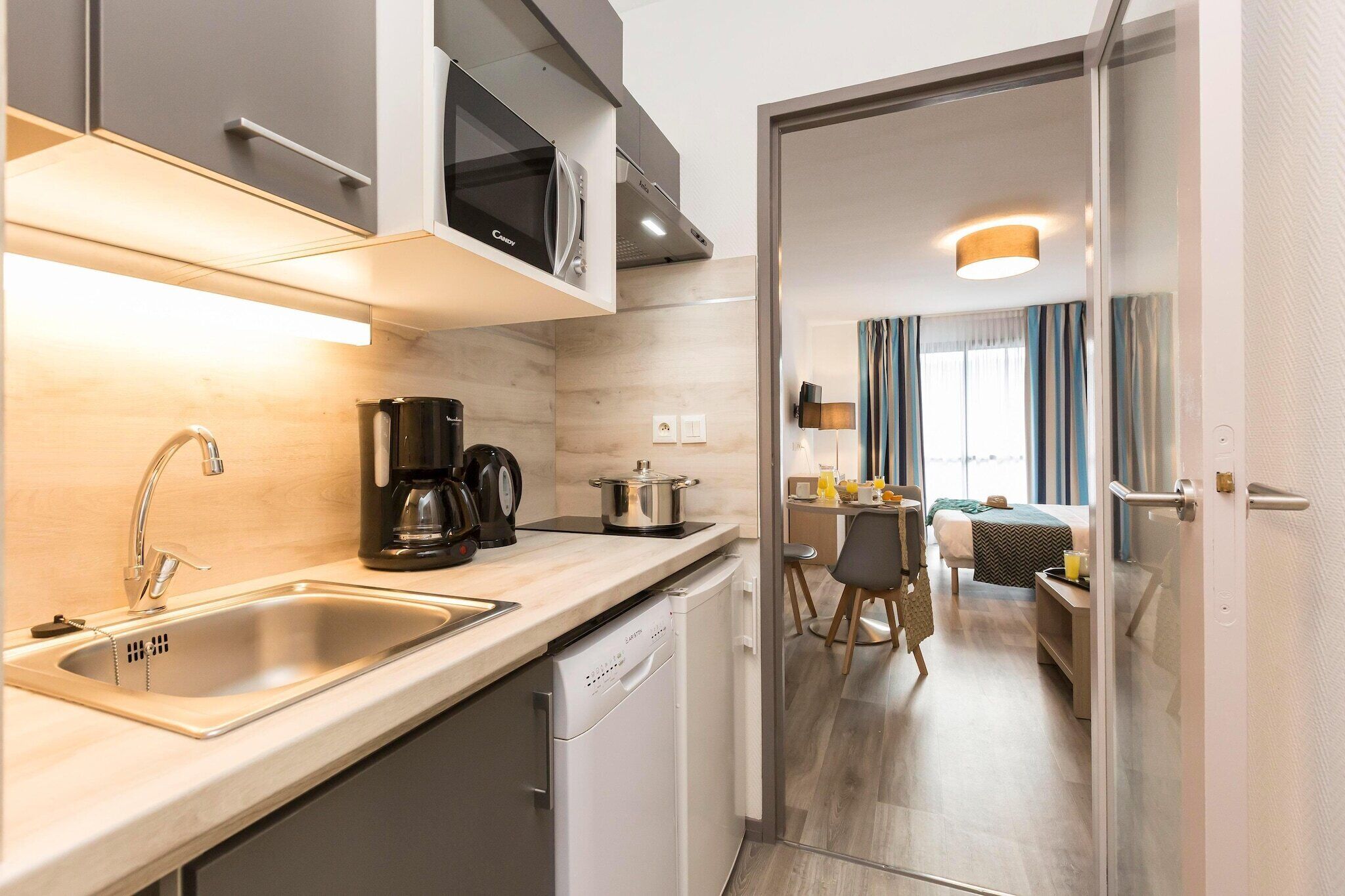 A modern kitchen with a built-in microwave, coffee maker, and dishwasher.