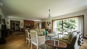 Un salón espacioso con un sofá, sillas, una mesa de centro y un comedor.