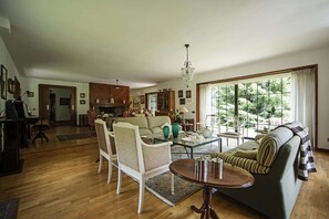 A spacious living room with a sofa, chairs, a coffee table, and a dining area with a table and chairs. - Chalet in Vielha near Baqueira Ski Resort (Vielha)