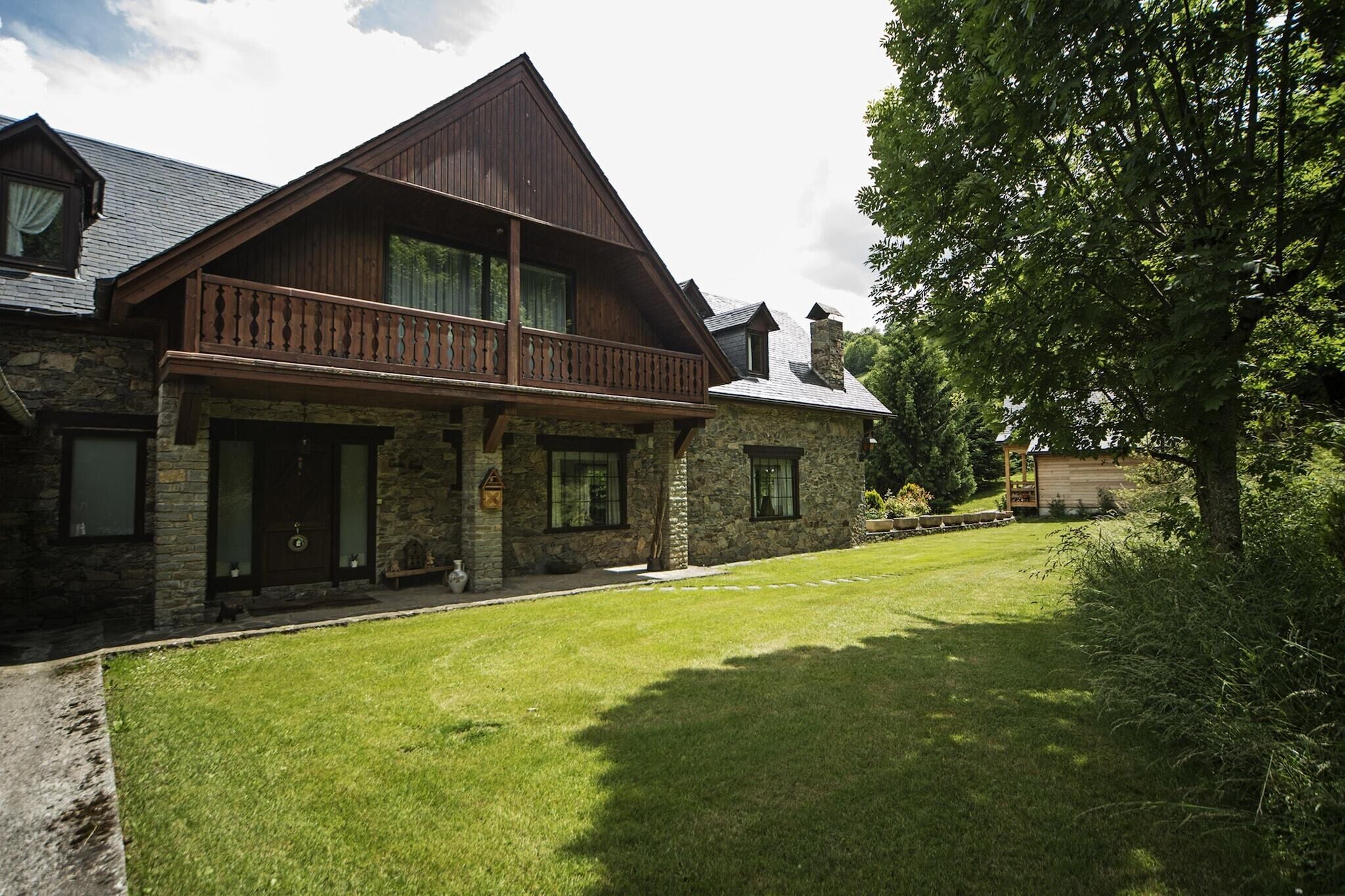 Une maison en pierre avec un balcon en bois, une cheminée en pierre et une pelouse bien entretenue.