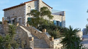 A stone building with a staircase leading to a balcony. - Villa in Kamilari near Kid-Friendly Beach (Kamilari)