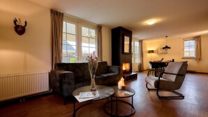 Una sala de estar acogedora con chimenea, un sofá, una mesa de centro y un sillón.