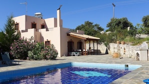 A pool with blue mosaic tiles, a building with a beige facade, and a stone wall. - Villa in Axos with Pool near Panormo Beach (Axos - Rethymno)