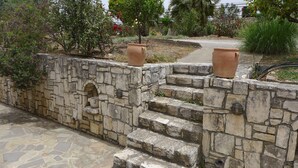 A stone staircase leading up to a garden area with terracotta pots on the steps. - Villa in Axos with Pool near Panormo Beach (Axos - Rethymno)