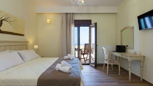 Une chambre d’hôtel équipée d’un lit, d’un bureau, d’une chaise, d’une télévision et offrant une vue sur l’extérieur.