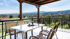 Un balcón con mesa y sillas que da a un paisaje pintoresco.