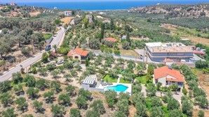 Vista aérea de una zona residencial con casas, una piscina y una carretera.