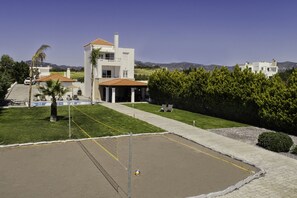 A residential property with a swimming pool, a covered patio, and a view of the surrounding landscape.
