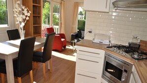A modern kitchen with a wooden countertop, white cabinets, and a built-in oven. - Chalet in Parc de Kievit with Private Garden (Baarle-Nassau)