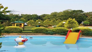 Una piscina con tobogán y zona de juegos infantiles.