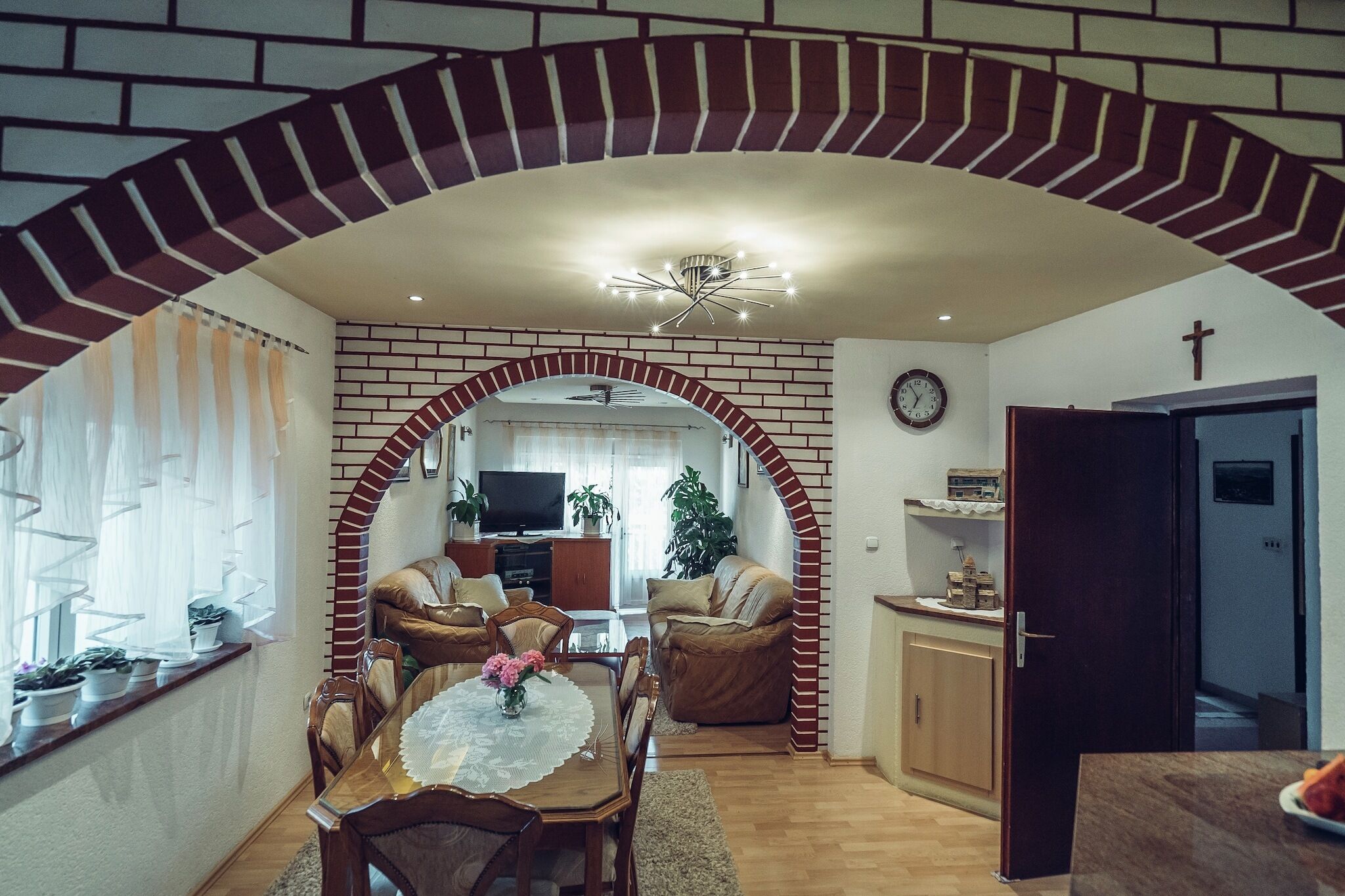 Un soggiorno con zona pranzo, TV e una scala che conduce a un piano superiore.