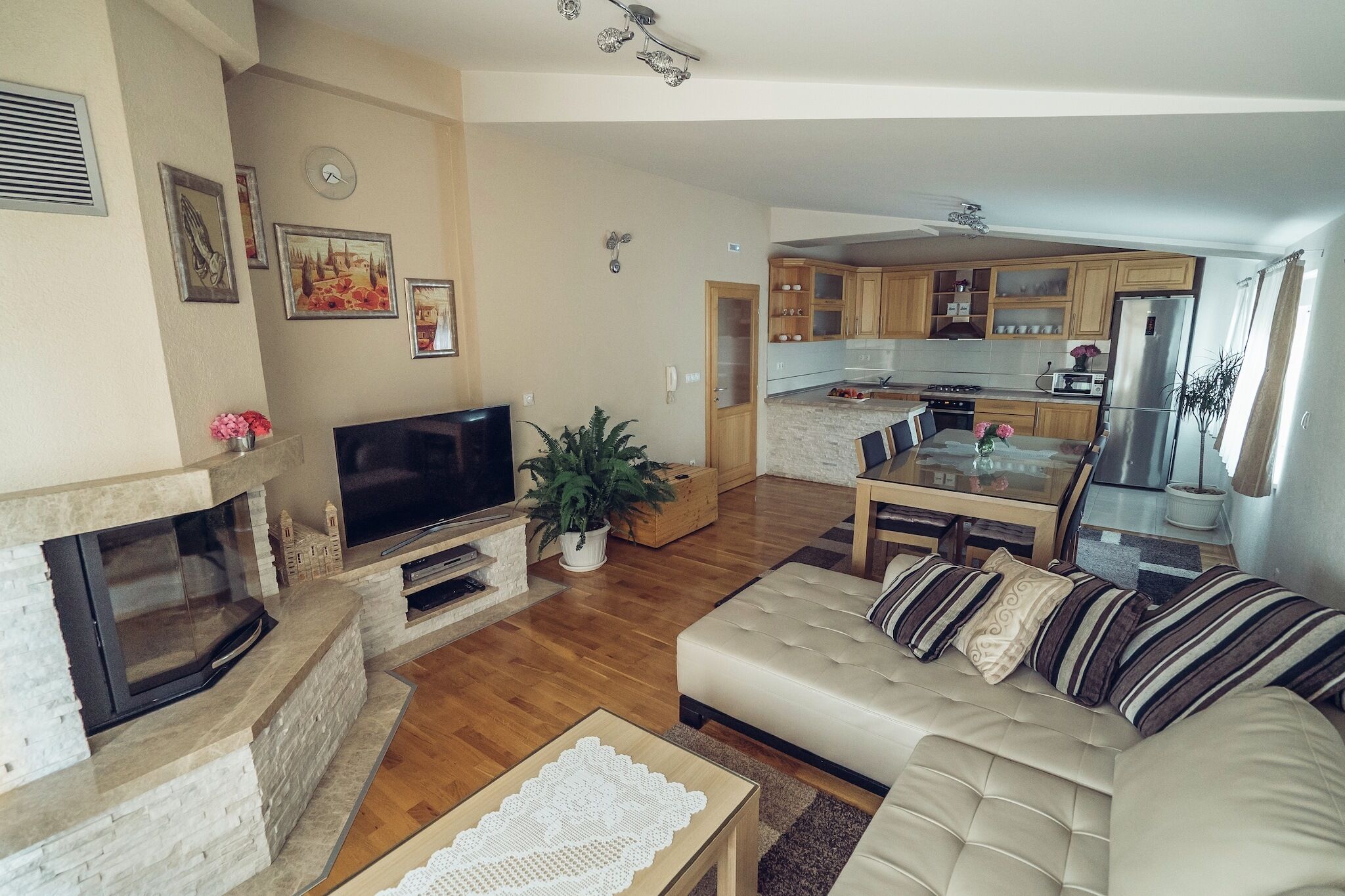 A living room with a fireplace, television, sofa, and dining area.