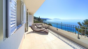 A balcony with two sun loungers, a view of the sea, and a railing. - Villa in Cres with Sea Views & Pool (Martinšćica)