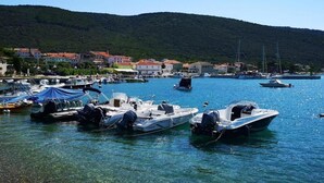 A marina with boats docked, a hilly backdrop, and buildings along the shore. - Villa in Cres with Sea Views & Pool (Martinšćica)