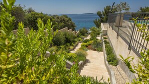 A staircase leading to a balcony overlooking a pool, surrounded by greenery and a clear view of the sea. - Villa in Cres with Sea Views & Pool (Martinšćica)