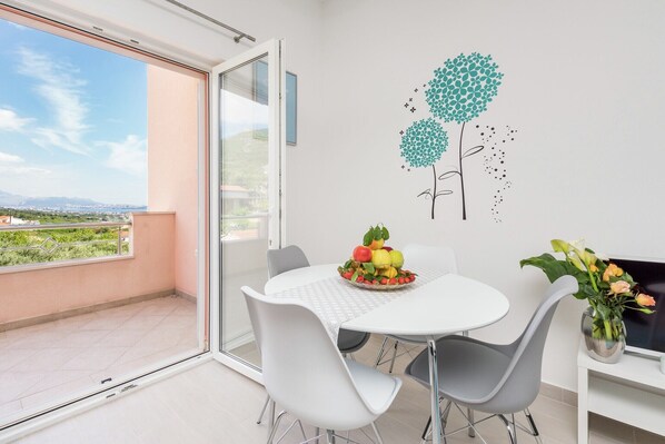 Un comedor con mesa, sillas y una obra de arte decorativa en la pared.