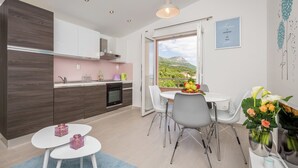 Eine moderne Küche mit Essbereich, Blick ins Freie und einer dekorativen Wandgestalt.