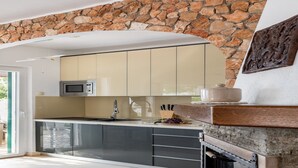 Eine moderne Küche mit einer Steinwand, einer Mikrowelle, einem Spülbecken und einer Holzauskład.